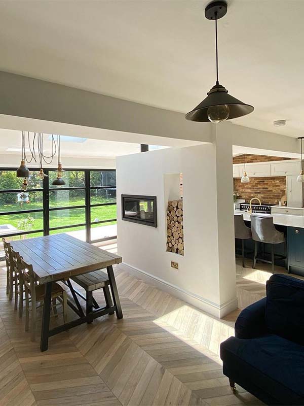 open plan kitchen and dining area, parquet flooring white walls, plants and open brick walls 
