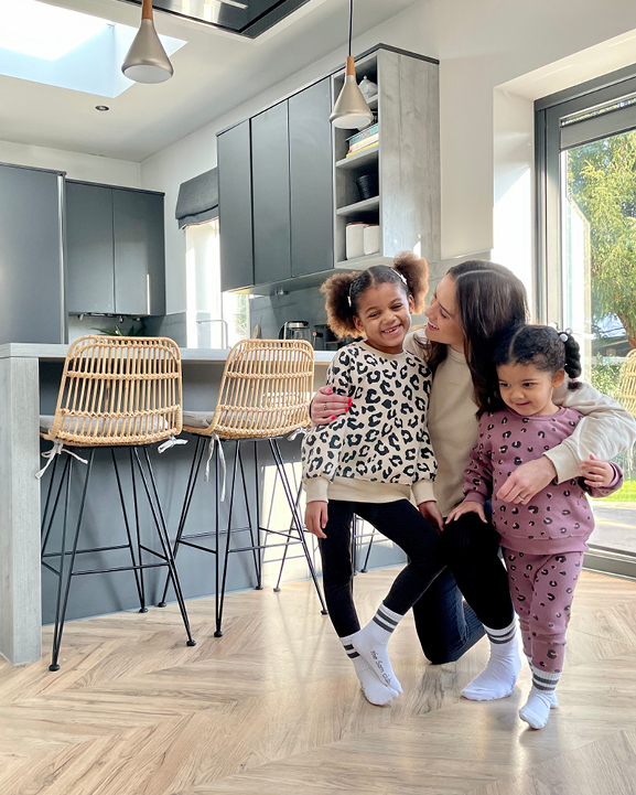 Family picture with mum and two daughters in modern kitchen