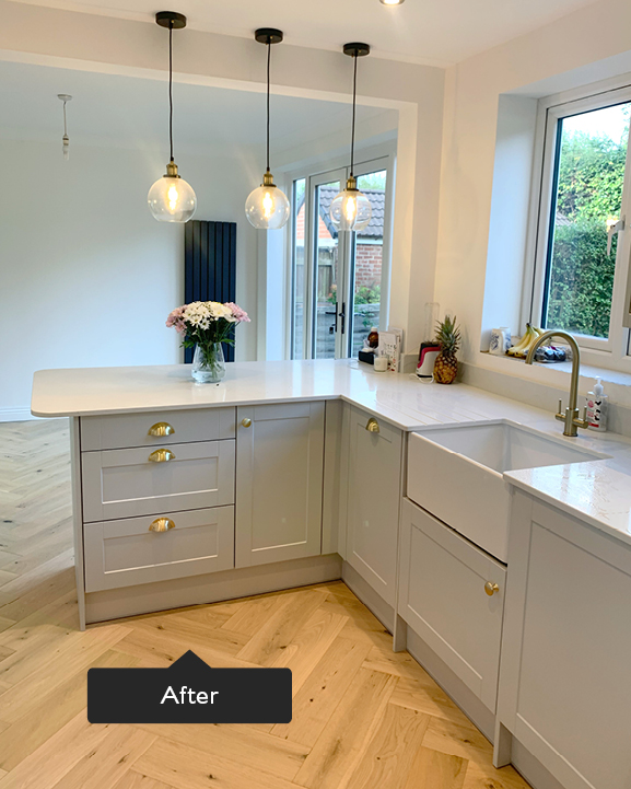 Herringbone flooring in duck egg coloured kitchen with white work tops and gold detailing